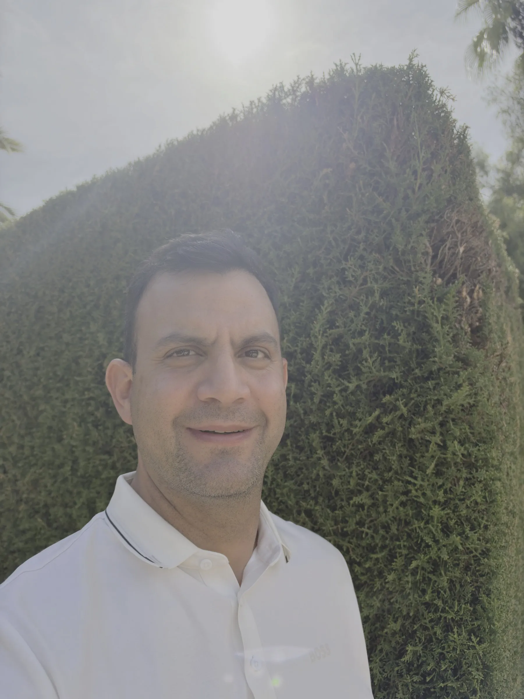 Apple Log: Carlos a contraluz delante de un seto, con el sol detrás